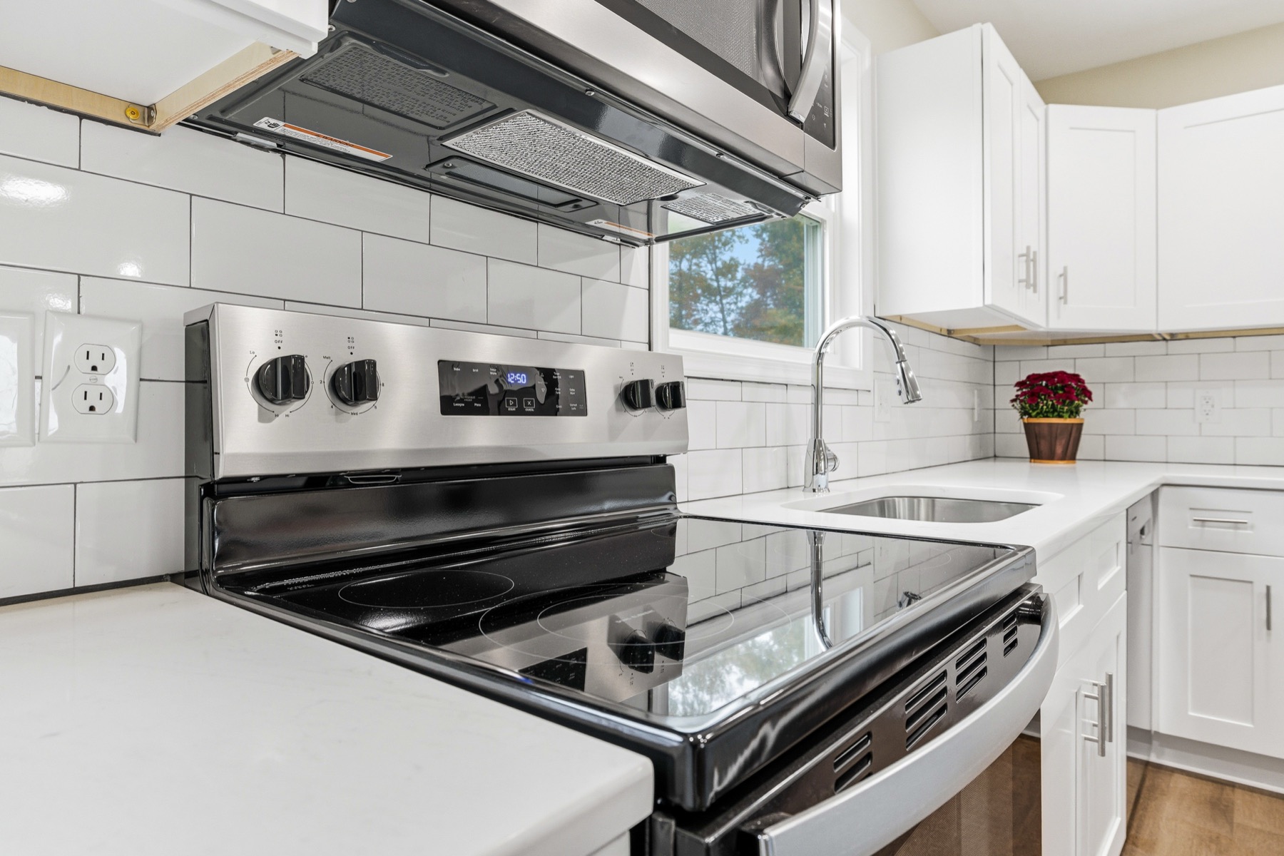 Kitchen detail with subway tile backsplash, stainless range and quartz countertop